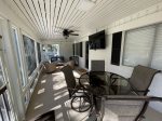 Screened Porch off Pool Deck with TV and Dining Table at 16 Ibis Street